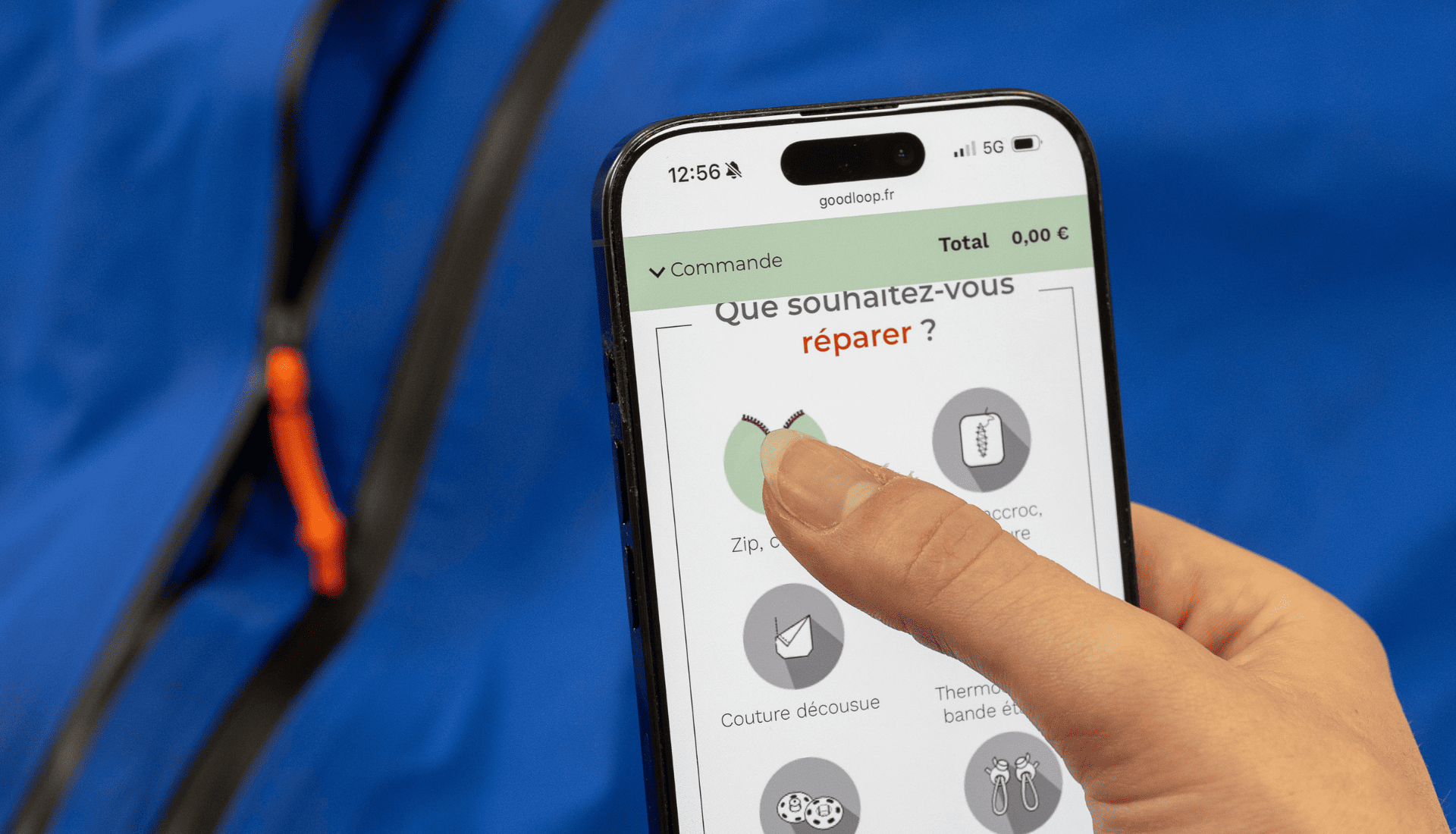 commande-reparation-zip-casse-formulaire-goodloop.jpg Une personne commande une réparation sur le formulaire Goodloop pour un zip cassé, avec une veste bleue en arrière-plan.
