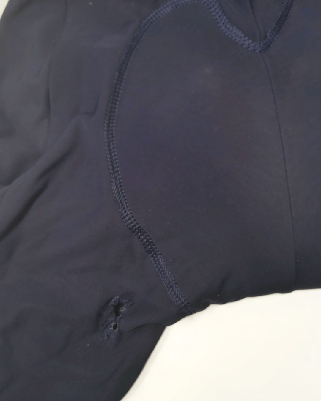 Cuissard de cyclisme présentant un trou avant réparation.