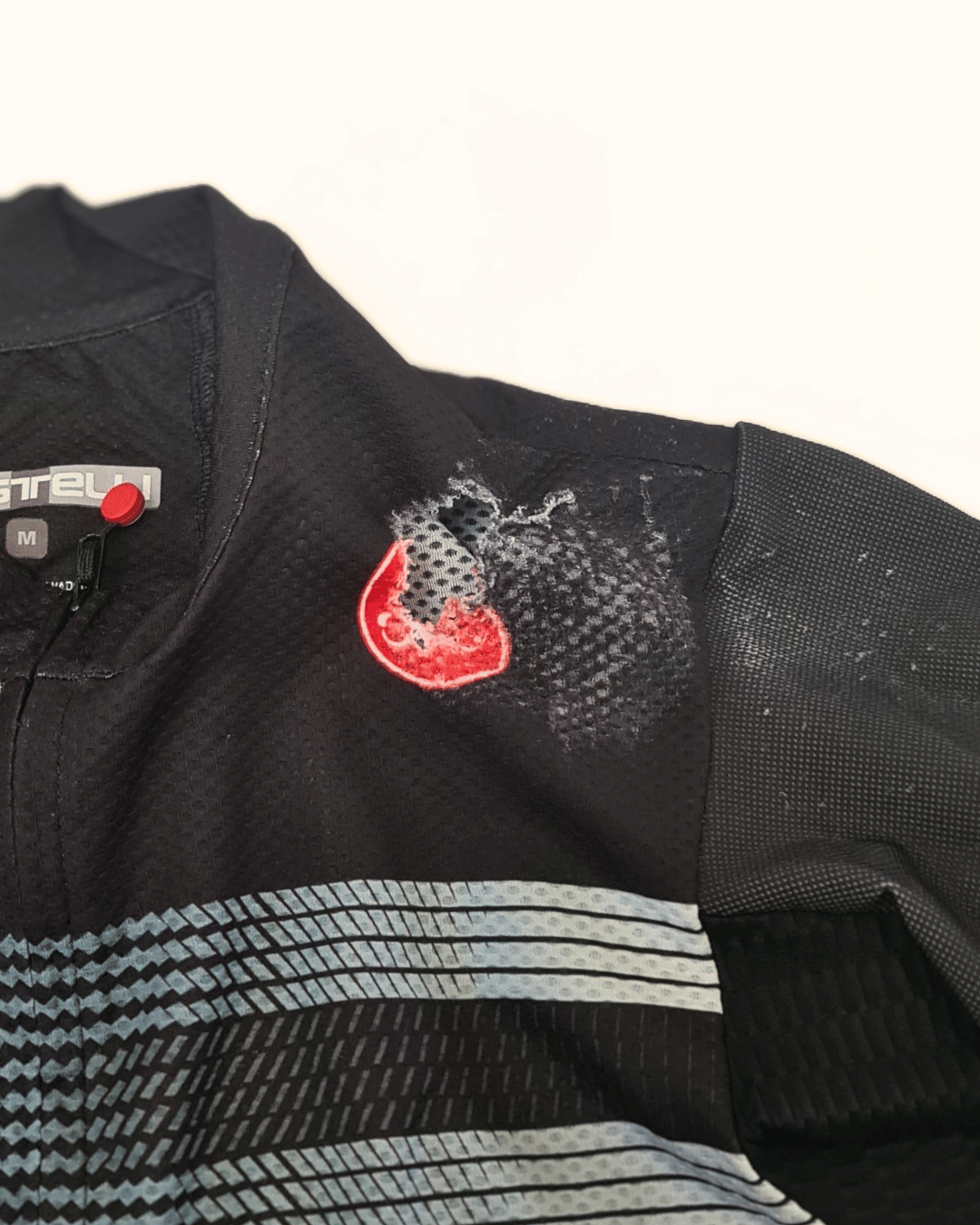 Maillot de cyclisme troué avant réparation.