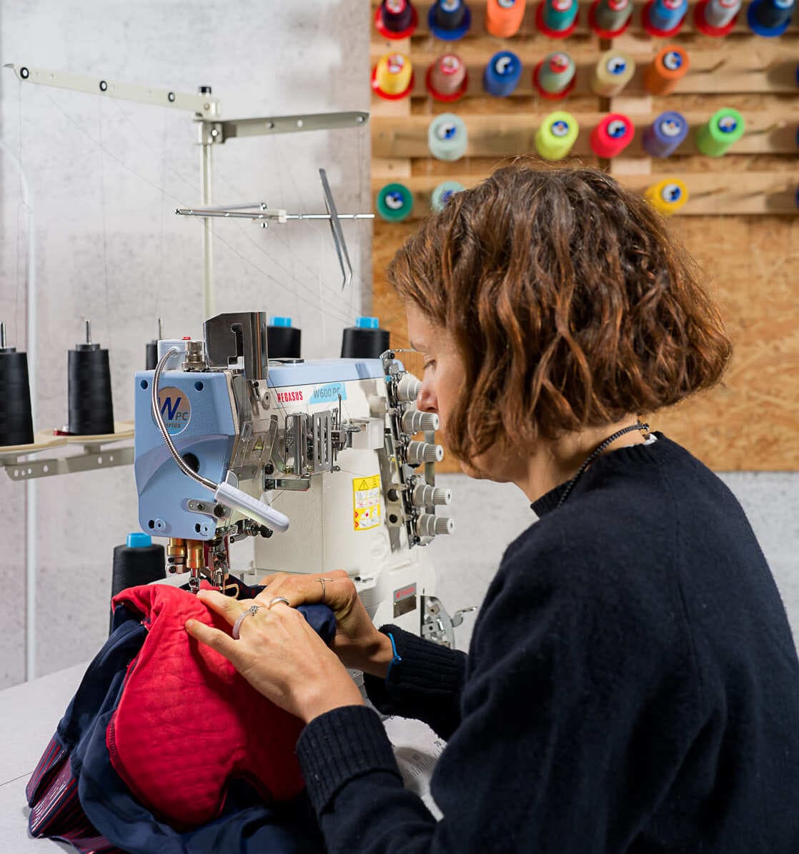 Une couturière Goodloop recoud le chamois décollé d’un cuissard de cycliste.