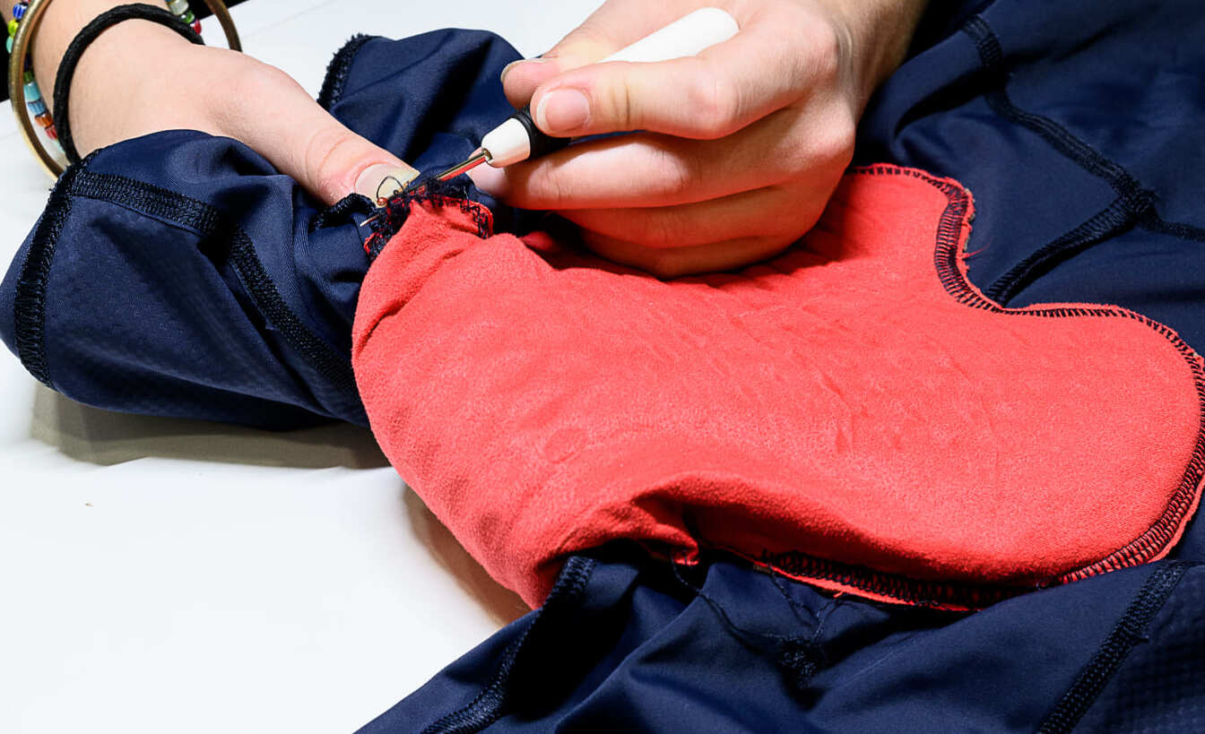 Réparation d'un cuissard de cyclisme avec une couture décousue dans l’atelier de réparation Goodloop.