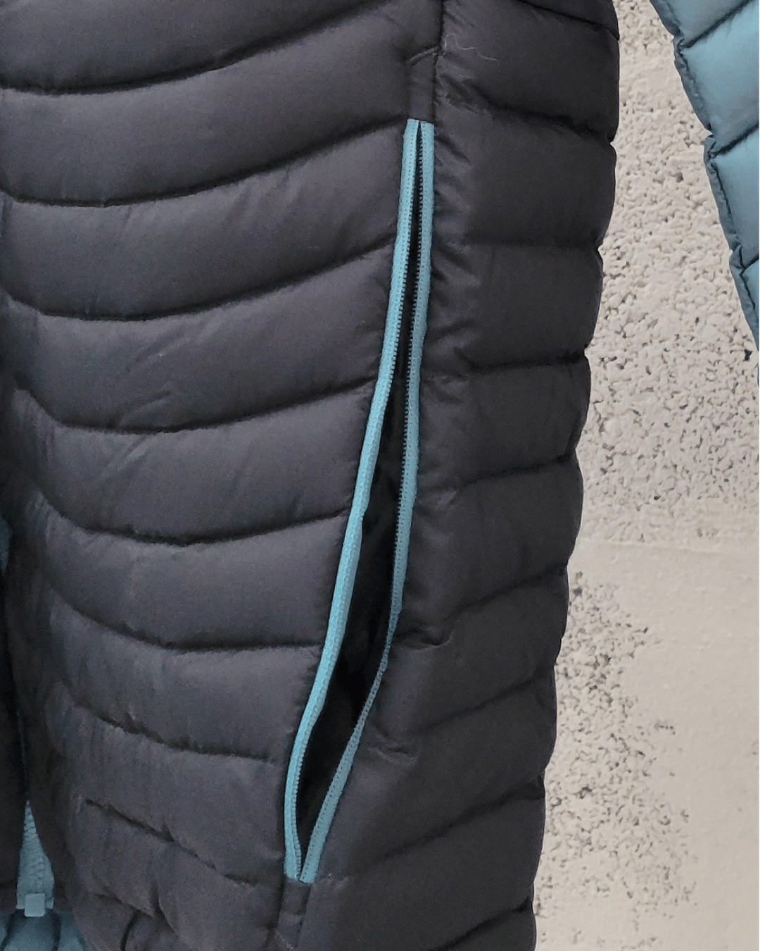 Curseur de zip cassé et fermeture éclair défectueuse sur une doudoune Salewa avant réparation.