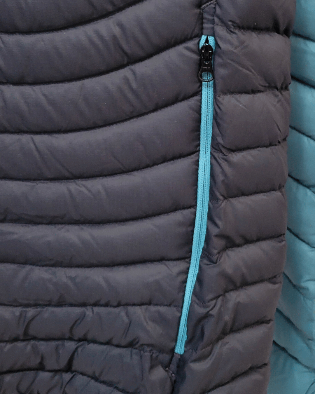 Nouveau curseur de fermeture éclair installé sur une doudoune Salewa après réparation.