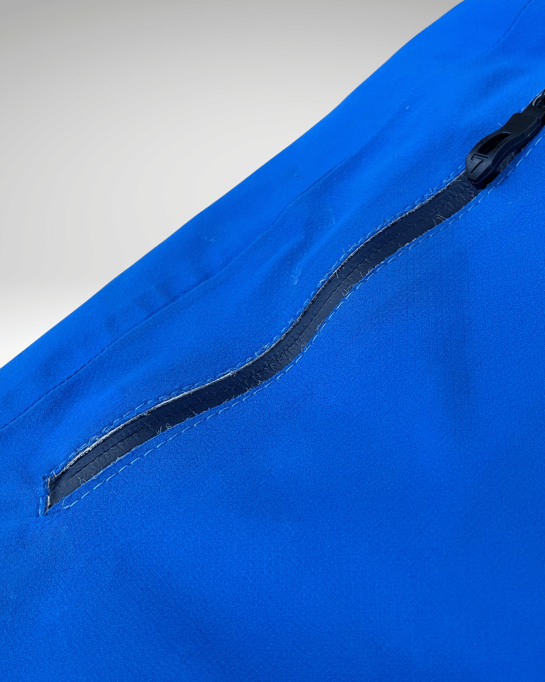 Poche de veste réparée par Goodloop : recollée et renforcée par une couture solide autour du zip