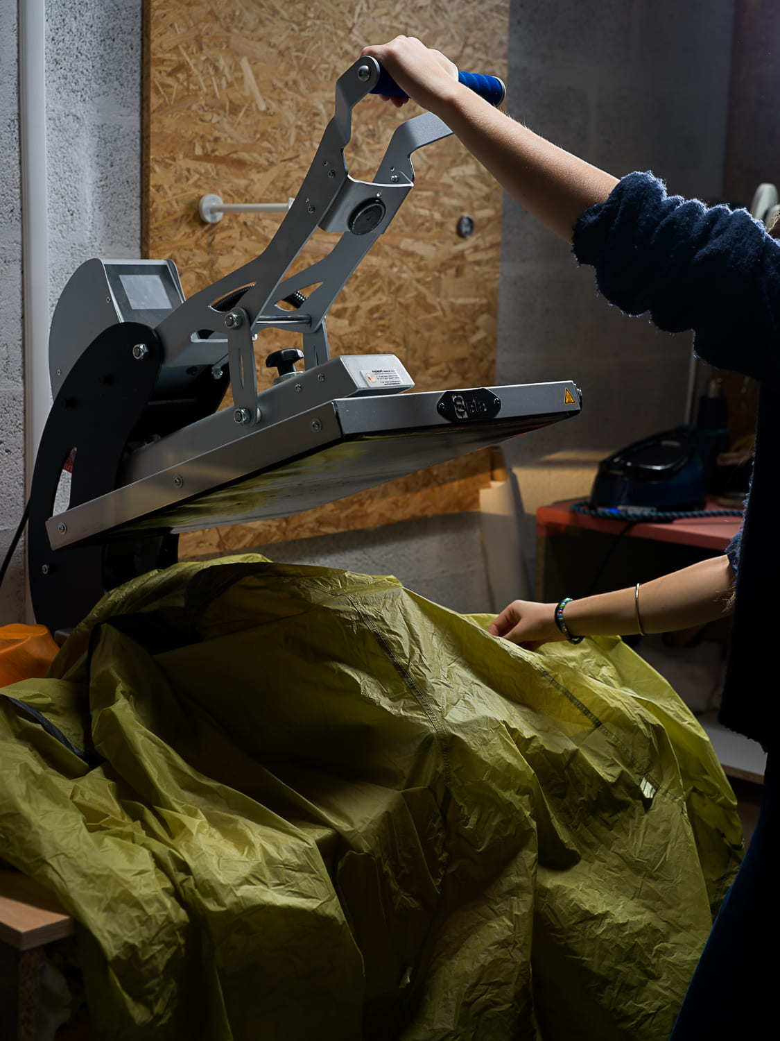 Application de bandes étanches thermocollées sur les coutures d'une tente Nemo à l'aide d'une presse à chaud professionnelle