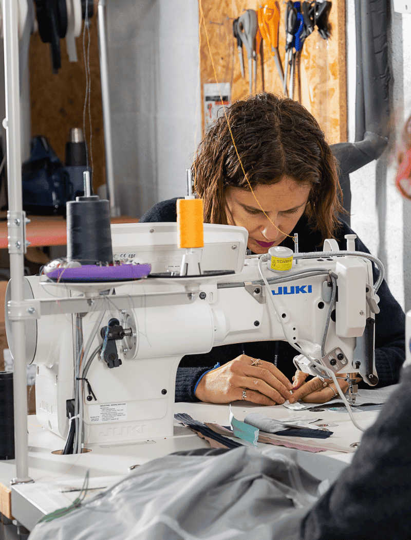 Couturiers de l'atelier Goodloop en train de réparer des vestes et équipements techniques