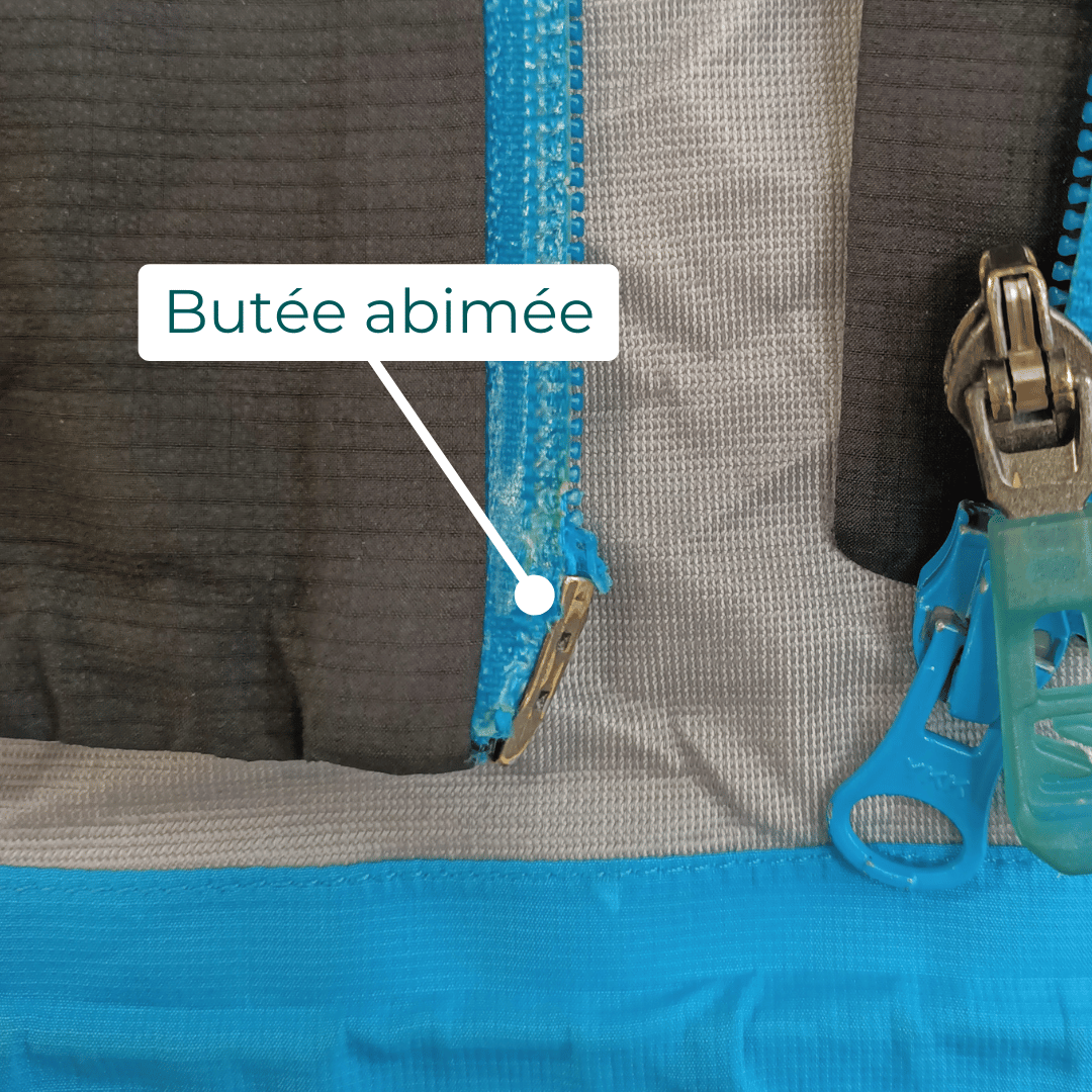 Photo avec légende fléchée montrant une butée de fermeture éclair abîmée nécessitant un remplacement complet