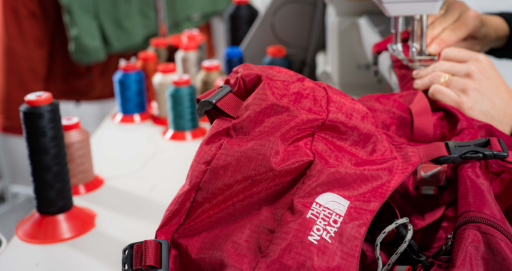 Réparation d’un sac à dos de randonnée The North Face dans l’atelier Goodloop.